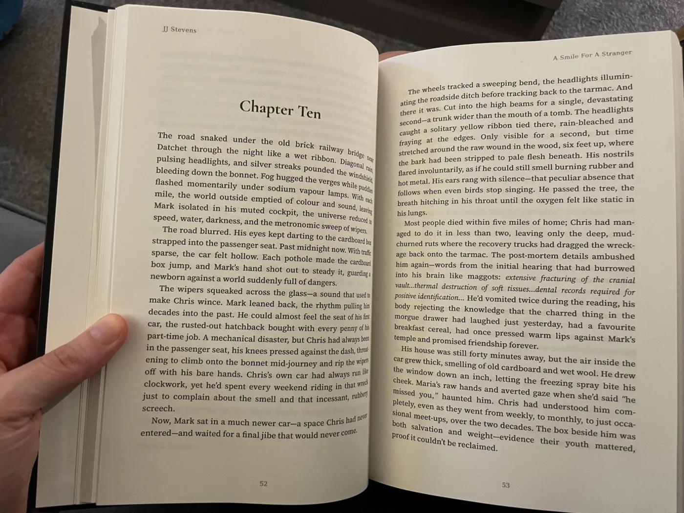 A hardback copy of A Smile For A Stranger by JJ Stevens, open at a chapter page formatted with Koberger